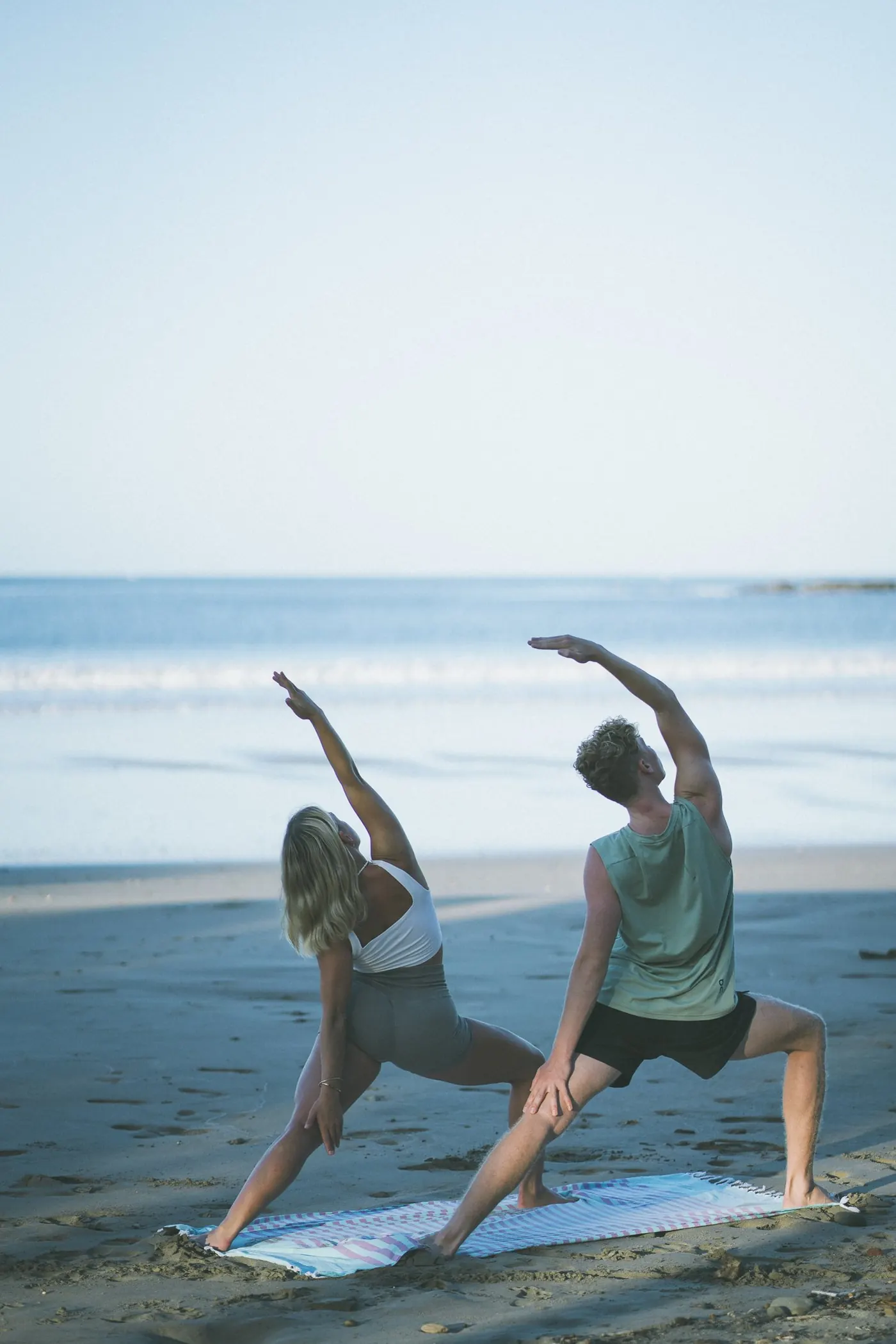 Soph and Josh in warrior pose on the beach
